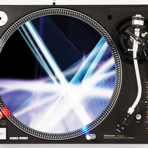 Puede incluir: Un tocadiscos negro con un brazo plateado y una alfombrilla de deslizamiento con un patrón blanco y azul. El tocadiscos tiene un botón de inicio y parada, una perilla de control de tono y un logotipo de Technics.