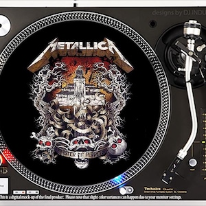 May include: A black turntable with a Metallica "Master of Puppets" design on the record. The design features skulls, a castle, and the band's logo. The turntable has a silver arm and a black base. The text "designs by DJ INDUSTRIES" is visible.