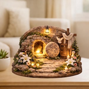 May include: A decorative Easter scene featuring a stone tomb with a glowing interior. The scene includes a large stone, a wooden cross, a white dove, and lit candles. Flowers and greenery surround the tomb, creating a serene atmosphere.