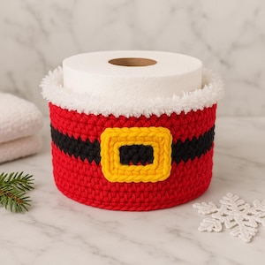 May include: A red crocheted toilet paper holder, styled as Santa Claus's suit. It has a black belt with a yellow buckle and a white fluffy trim. The holder is designed to hold a roll of toilet paper, adding a festive touch to the bathroom.