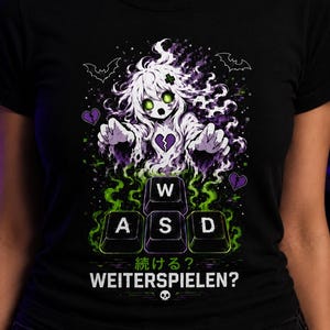 Könnte beinhalten: Ein schwarzes T-Shirt mit einer Grafik eines weißhaarigen Geistes mit leuchtend grünen Augen, der nach vorne greift. Unter dem Geist befinden sich vier Tastaturtasten W, A, S, D in grünem Rauch, mit dem Text 続ける? WEITERSPIELEN? und einem Totenkopf.