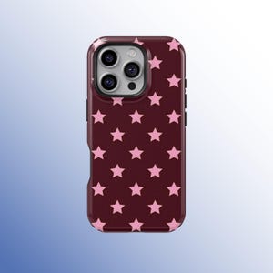 Puede incluir: Funda de teléfono burdeos con un patrón de estrellas rosas. La funda tiene un parachoques protector alrededor de los bordes y recortes para las lentes de la cámara. Las estrellas están espaciadas uniformemente.