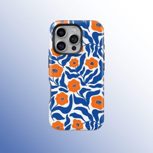 May include: A white phone case with a vibrant floral pattern. The design features orange flowers with blue centers and blue leaves against a white background. The case has a blue border and a camera cutout.
