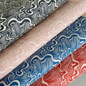 Puede incluir: Cuatro piezas de tela con un patrón repetitivo de líneas onduladas en blanco y negro. La tela está en capas, con la capa superior en blanco y negro, la segunda capa en rosa, la tercera capa en azul y la capa inferior en rojo.