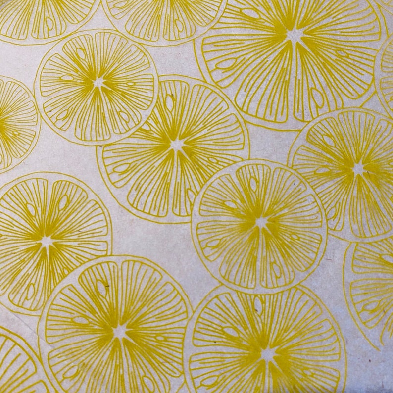 Pode incluir: Um fundo branco com um padr&atilde;o repetitivo de fatias de lim&atilde;o amarelas. As fatias de lim&atilde;o s&atilde;o desenhadas de forma estilizada, com linhas que irradiam do centro.