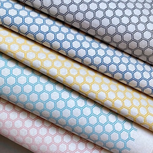 Peut inclure: Quatre rouleaux de papier de soie blanc avec un motif en nid d'abeille imprimé en différentes couleurs : noir, bleu, jaune et rose.