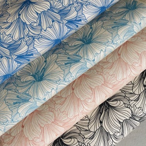 Puede incluir: Cuatro rollos de papel de regalo estampado con diseños florales. El papel es en tonos azules, rosas y negros.