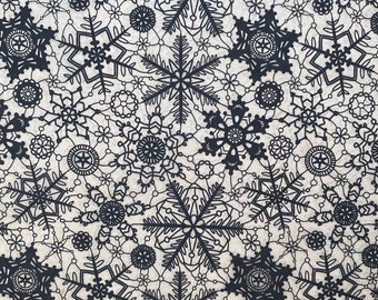 May include: Black and white snowflake pattern on a beige background. The snowflakes are intricate and detailed, creating a delicate and elegant design.