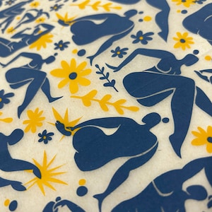 Puede incluir: Un patrón de figuras azules sobre un fondo crema con flores amarillas. Las figuras son estilizadas y abstractas, con formas redondeadas y líneas fluidas. Las flores son simples y estilizadas, con cinco pétalos cada una.