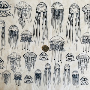 Może przedstawiać: Powtarzający się wzór czarnych ilustracji meduz na jasnobeżowym tle. Meduzy różnią się rozmiarem i stylem, ze szczegółowymi rysunkami linii ich dzwonów i macek. Moneta o wartości ćwierć dolara amerykańskiego jest dołączona do skali.