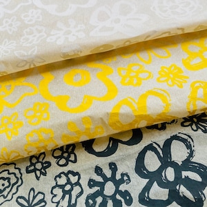 May include: Three layers of tissue paper with different floral patterns. The top layer is white with a light grey floral pattern. The middle layer is white with a yellow floral pattern. The bottom layer is white with a black floral pattern.