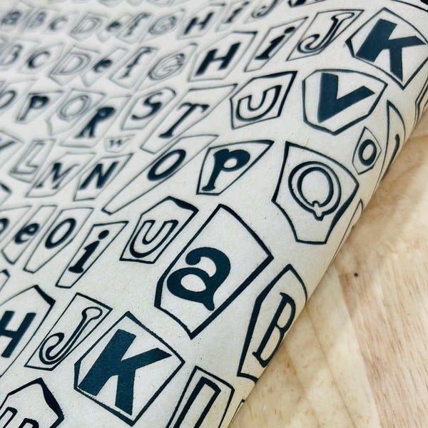 Könnte beinhalten: Eine weiße Keramik-Tasse mit schwarzem Henkel und dem Text "But First, Coffee" in schwarzer, handschriftlicher Schrift. Die Tasse steht auf einer weißen Oberfläche.