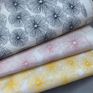 Pode incluir: Tr&ecirc;s folhas de papel de embrulho com um padr&atilde;o de fatias de lim&atilde;o. A folha superior tem fatias de lim&atilde;o pretas sobre um fundo branco. A folha do meio tem fatias de lim&atilde;o cor-de-rosa sobre um fundo branco. A folha inferior tem fatias de lim&atilde;o amarelas sobre um fundo branco.