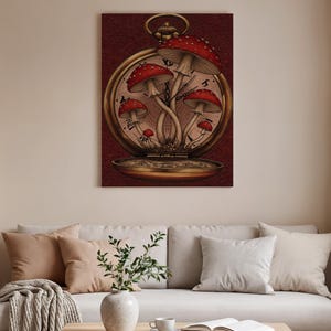 Puede incluir: Una obra de arte enmarcada que presenta un diseño de reloj de bolsillo vintage. La esfera del reloj muestra un grupo de setas rojas y blancas moteadas. El fondo es de color rojo intenso y la caja del reloj tiene un acabado dorado.