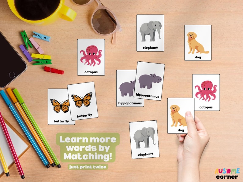 May include: Flashcards featuring animal illustrations, such as an elephant, dog, and octopus, displayed on a wooden surface. The cards are accompanied by the text "Learn more words by Matching!" and "just print twice".