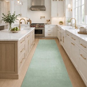 Könnte beinhalten: Ein Set aus drei Keramikbechern mit gesprenkelter, matter Oberfläche. Die Becher sind in Creme-, Hellgrau- und Dunkelgrautönen gehalten. Jeder Becher hat ein schlichtes, modernes Design und einen abgerundeten Henkel. Die Becher sind aufeinander gestapelt.