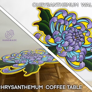 Può includere: Tavolino e arte murale a forma di crisantemo fatti a mano. Il tavolo presenta un grande motivo floreale stilizzato nei toni del viola, blu e giallo, con foglie verdi. L'arte murale mostra lo stesso design. I testi "Chrysanthemum Wall Art" e "Chrysanthemum Coffee Table" sono visibili.