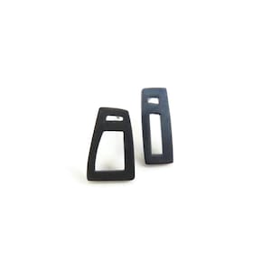 Asymmetrische, rechthoekige oorbellen van geoxideerd sterling zilver met verschillende geometrische vormen.