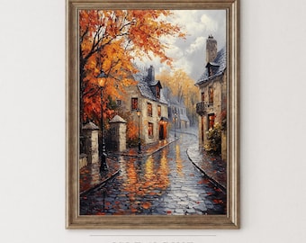 May include: Framed art print of a European street scene in autumn. The painting depicts cobblestone streets, buildings with lit windows, and trees with orange and red leaves. The artwork is signed "Isle & Pine Art Collection."