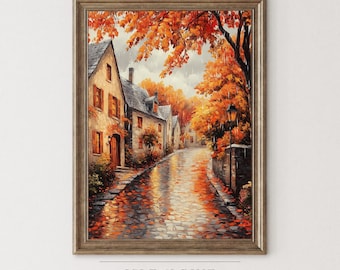 May include: Framed art print of a European village street scene in autumn. The cobblestone street reflects the orange and yellow hues of the fall foliage. Buildings with orange shutters line the street. The artwork is from the "Isle & Pine Art Collection."