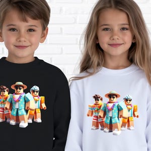 Puede incluir: Sudaderas negras y blancas con un gr&aacute;fico colorido de tres figuras en bloques con atuendo tropical. Las figuras llevan gafas de sol, sombreros y leis. Las sudaderas las llevan ni&ntilde;os.