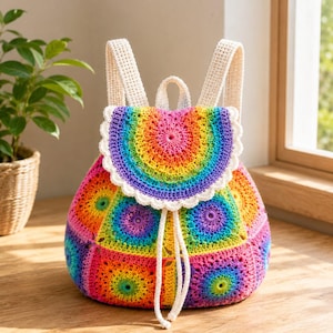 May include: A colorful, handmade crochet backpack. The bag features a rainbow design with a scalloped flap and cream-colored straps. The drawstring closure and overall design suggest a bohemian or festival style.