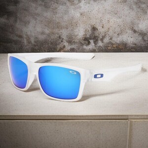 May include: White sunglasses with blue mirrored lenses. The sunglasses have a rectangular frame and a white arm with a blue logo. The lenses reflect a bright blue color.
