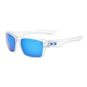 May include: Clear-framed sunglasses with blue mirrored lenses. The sunglasses have a rectangular shape and a blue logo on the temples. The lenses reflect a bright blue color.