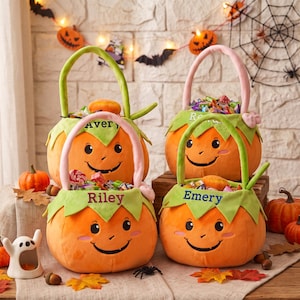 May include: Four plush pumpkin-shaped Halloween candy buckets with handles. Each bucket features a smiling face, green leaf-shaped trim, and embroidered names including Avery, Riley, and Emery. The buckets are filled with assorted colorful candies.