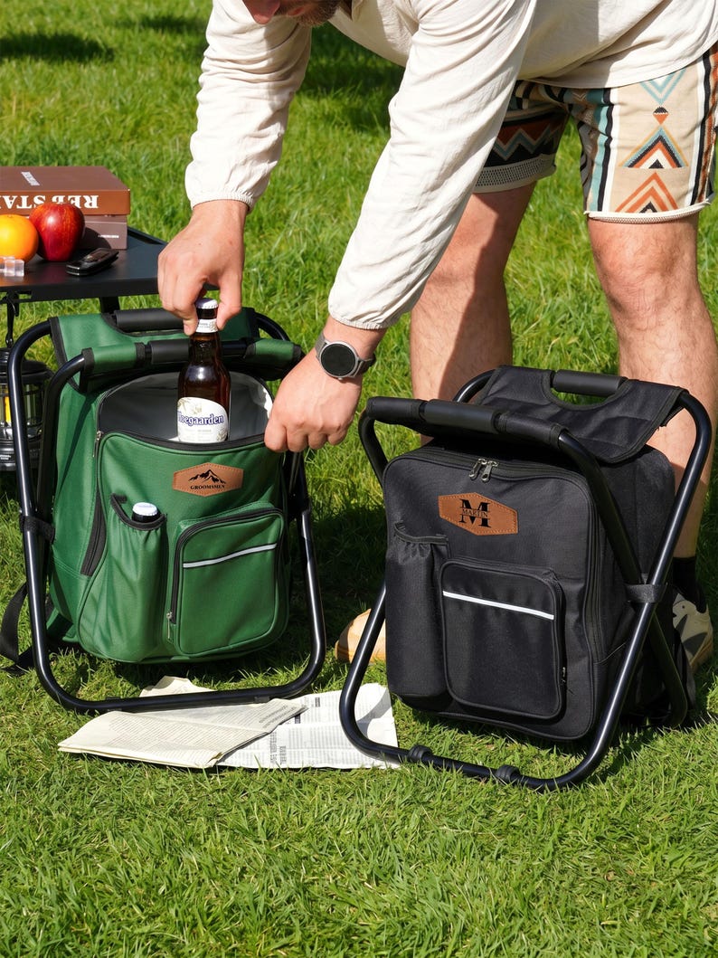 May include: Two portable cooler backpacks with integrated folding stools, one in forest green and one in black. Each bag features a front zippered pocket, a side bottle holder, and a brown leather-like patch with custom text branding.