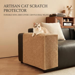 Op de afbeelding: Een kat zit op een bruine sisal geweven armleuningbeschermer. De beschermer is ontworpen om de bank te beschermen tegen krassen. Tekst op de afbeelding luidt "ARTISAN CAT SCRATCH PROTECTOR" en "DURABLE SOFA ARM COVER | GENTLE SISAL WEAVE". De bank is zwart.