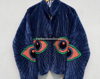 May include: A navy blue velvet jacket with a high collar and a zipper closure. The jacket features an embroidered eye design in red, green, and black. The brand name "Farhanhandicraft" is visible on the jacket.