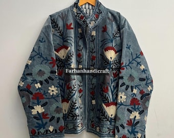May include: A blue embroidered jacket with a high collar, featuring floral patterns in red, white, and blue. The jacket is buttoned up and hangs on a wooden hanger. The text "Farhanhandicraft" is visible.