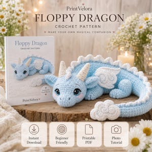 May include: A crochet pattern booklet titled Floppy Dragon Crochet Pattern by PrintVelora, featuring a light blue crocheted dragon toy with white horns, wings, and tail accents. The booklet includes text for instant download, beginner friendly, printable PDF, and photo tutorial.