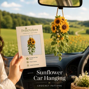 Könnte beinhalten: Ein gehäkelter Sonnenblumen-Autoanhänger mit gelben Blütenblättern, braunen Mitten, grünen Blättern und kleinen weißen Blüten, an einer Schnur hängend. Daneben liegt eine gedruckte Anleitung mit dem Titel PrintVelora Crochet Pattern.