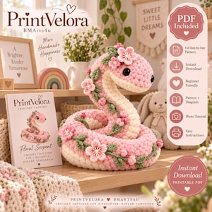 Op de afbeelding: Een haakpatroon voor een bloemige slang, met een roze en crèmekleurige opgerolde slang versierd met kleine groene blaadjes en roze bloemen. De set bevat een gedrukt boekje genaamd PrintVelora Floral Serpent en een digitale PDF-gids.