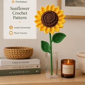 Pode incluir: Um girassol de crochê com centro castanho escuro e pétalas amarelo brilhante num caule verde com duas folhas, exibido num vaso de vidro transparente canelado. O texto à esquerda diz PrintVelora Sunflower Crochet Pattern, Instant Download, Photo Tutorial.