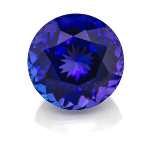 May include: A round, faceted gemstone with a deep, vibrant royal blue color. The stone features a precise circular cut with numerous triangular and kite-shaped facets that create a star-like pattern of light reflection across its surface.