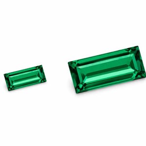 以下が含まれることがあります： 白い背景に、鮮やかな緑色のエメラルドカットの宝石が2つあります。宝石は長方形で、1つはもう1つより大きいです。ファセットが光を捉え、きらめく効果を生み出しています。これらの宝石はジュエリーに最適です。