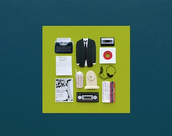 May include: A green background with a collage of various items, including a black suit jacket, a typewriter, a cassette tape, a record, a milkshake, a clock, headphones, a poster, and a stack of books. The poster reads "Punk Rock Halloween Bash".