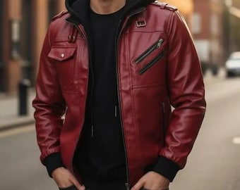 Puede incluir: Chaqueta de cuero burdeos con una sudadera con capucha negra debajo. La chaqueta tiene cremallera frontal, dos bolsillos en el pecho y dos bolsillos laterales. Tiene puños y cuello negros. La persona lleva vaqueros negros.