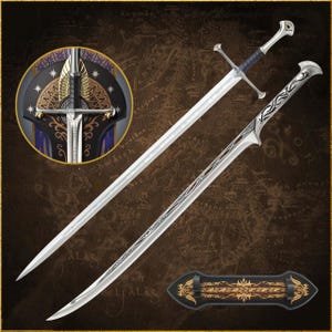 Può includere: Due spade d'argento con disegni intricati, una dritta e una curva, sono esposte su uno sfondo marrone con un motivo a mappa. Sono visibili anche un emblema circolare e un supporto per spade, con dettagli dorati e neri.