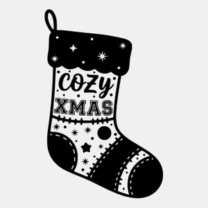 Peut inclure: Chaussette de Noël noire et blanche avec l'inscription "cozy XMAS" au centre. La chaussette a un bord festonné et est décorée d'étoiles et de points. Une boucle est en haut pour l'accrocher.