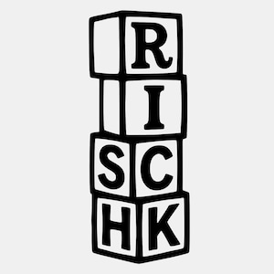 May include: A stack of four white toy blocks with black outlines and black letters spelling "RISK". The blocks are arranged vertically, with each block displaying a single letter.