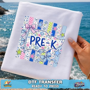May include: A white fabric sheet featuring a colorful graphic print of a pennant flag with the text PRE-K. The design includes blue floral patterns, pink and blue gingham stripes, light blue bows, and small green and pink stars on a striped background.