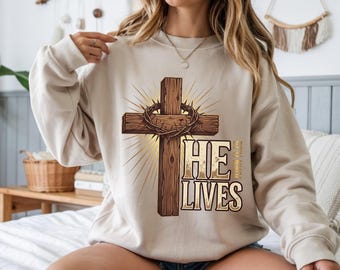 He Lives John 11:25 Christian Streetwear Sweatshirt | Jesus Merch Crown Thorns Cross Graphic Gildan 18000 Crewneck | Easter Gift For Mom
