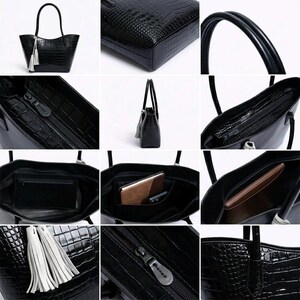 May include: Black tote bag with a crocodile-skin texture, featuring a tassel and double handles. The bag has a zippered closure and an interior pocket. The bag is made of a shiny material.