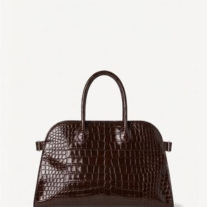 Puede incluir: Un bolso estructurado marr&oacute;n oscuro con una textura brillante de piel de cocodrilo. El bolso tiene una parte superior curvada, un asa corta y una base rectangular. Cuenta con herrajes m&iacute;nimos, con peque&ntilde;os cierres laterales.