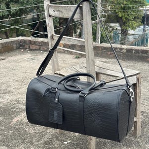 Crocodile Embossed Leather Duffel Bag in a luxury studio setting.