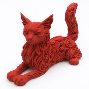 Op de afbeelding: Een rode kattenbeeldhouwwerk in een ontspannen pose. De vacht van de kat is gedetailleerd met wervelende patronen en de staart is gekruld. Het beeldhouwwerk staat op een witte achtergrond, wat de vorm en textuur van de kat benadrukt. Een decoratief item.